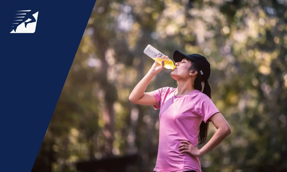 Eine Läuferin trinkt ein Sportgetränk mit Elektrolyten