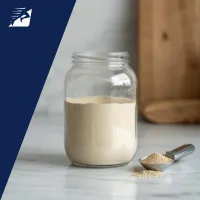 Ein Glas und ein Löffel mit Proteinpulver