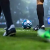 Ein Fußball und einige Füße auf dem Rasen