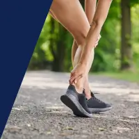 Eine Läuferin greift sich auf die Achillessehne