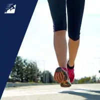 Die Beine einer Läuferin beim Laufen auf Asphalt