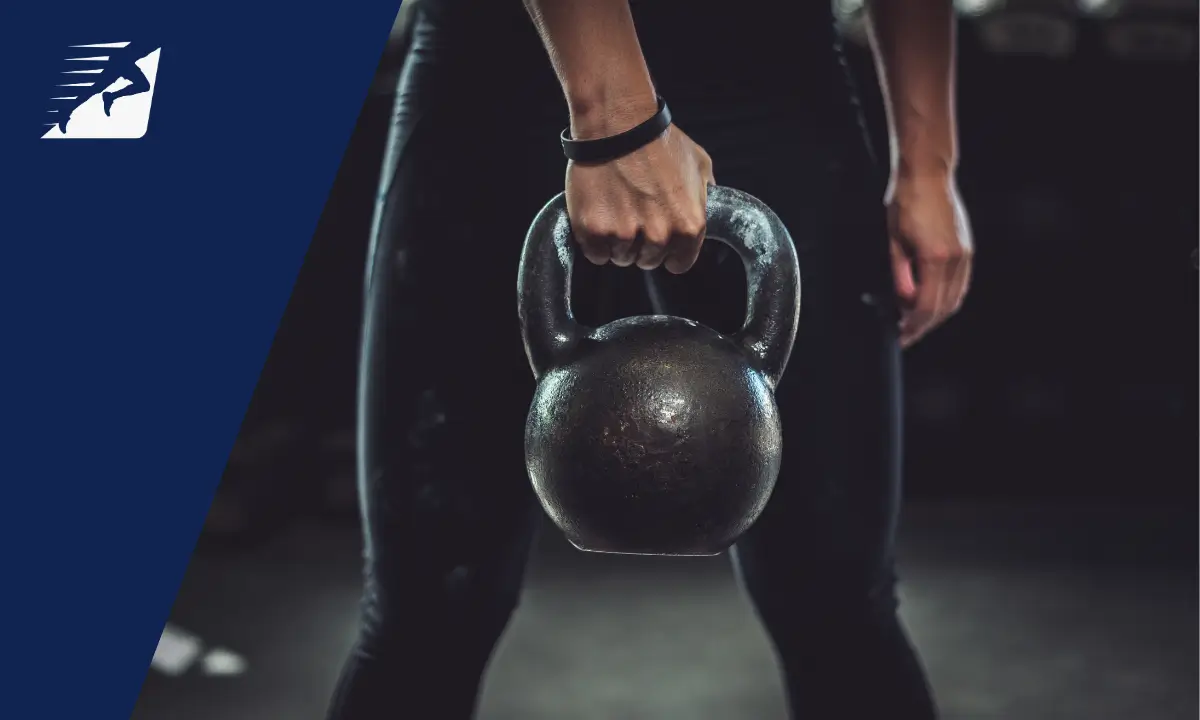 Eine Frau hebt Kettlebells in die Höhe