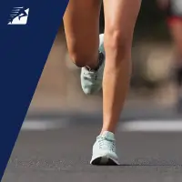 Die Beine einer Frau beim Laufen auf Asphalt