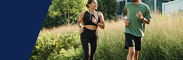 Eine Frau und ein Mann beim Laufen, die sich gegenseitig anlächeln.
