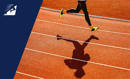 Die Beine einer Frau beim Laufen auf einer Laufbahn.