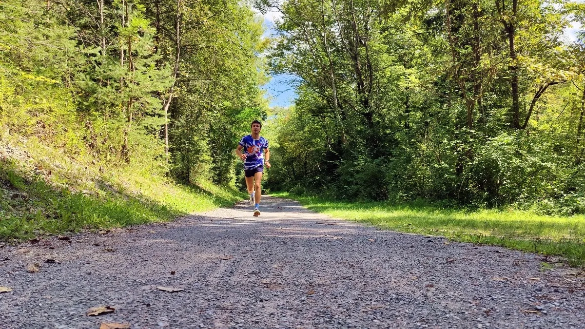 Ein Läufer läuft auf Schotter mit Anta Laufschuhen